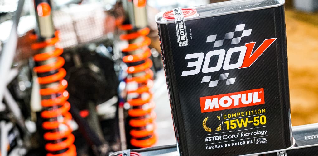Motul 300V Competition motor oil can in a race workshop